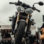 Front view of a motorbike parked outdoors on a cloudy day, showcasing its design.