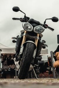 Front view of a motorbike parked outdoors on a cloudy day, showcasing its design.
